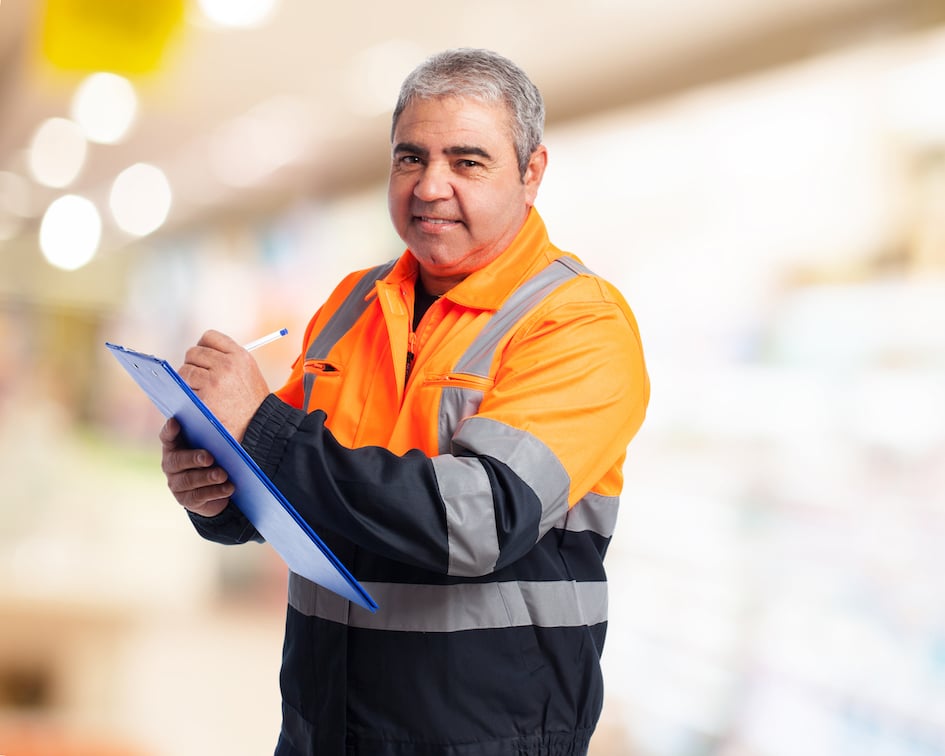 man-with-orange-overalls-taking-note